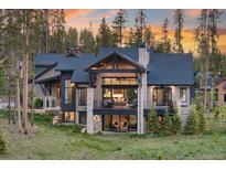 Stunning mountain home boasts an inviting exterior with natural wood and stone accents and beautiful sunset views at 60 Barton Ridge Dr, Breckenridge, CO 80424