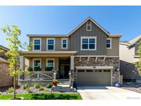 Charming two-story home with a covered porch and stone accents on the garage at 24326 E Ohio Dr, Aurora, CO 80018