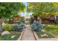 Charming two-story home with brick accents, mature trees, and manicured front yard at 7346 S Platte Canyon Dr, Littleton, CO 80128