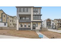 Modern three-story home featuring a mixed material facade with a balcony and an inviting entrance at 8846 Waterleaf Ln, Littleton, CO 80125