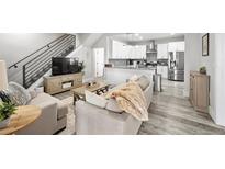 Open-concept living room and kitchen featuring modern design and stainless steel appliances at 800 S Krameria St, Denver, CO 80224
