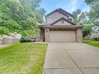 Charming two-story home with a two-car garage and stone accents, nestled in a well-manicured lawn at 124 High Country Trl, Lafayette, CO 80026