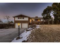 Brick ranch home with attached two-car garage and landscaped yard at 960 S Vance St, Lakewood, CO 80226