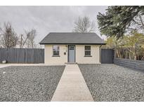 Charming exterior view of a single-story home featuring fresh paint, a gray roof, and a rock garden at 1525 Roslyn St, Denver, CO 80220