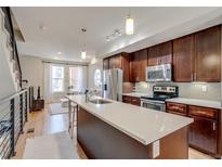 Modern kitchen features stainless steel appliances, white countertops and a functional island with a sink at 2426 Welton St, Denver, CO 80205