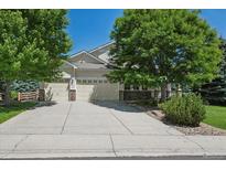 Charming two-story home with a three-car garage and a well-manicured front yard with mature trees at 5309 Mining Camp Trl, Parker, CO 80134