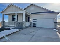 House exterior featuring a modern design, stone accents, and a two-car garage at 42974 Colonial Trl, Elizabeth, CO 80107