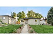 Charming exterior of this ranch-style home showcases a well-manicured lawn and inviting walkway at 3541 Eudora St, Denver, CO 80207
