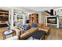 Bright living room features a leather sectional, fireplace and dining area at 6795 E Arizona Ave # B, Denver, CO 80224