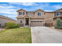 Two-story home showcasing neutral siding, a well-manicured lawn, and an attached two-car garage with a long driveway at 9535 Dexter Ln, Thornton, CO 80229