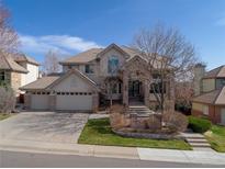 Stately two-story home with a three-car garage and beautifully landscaped front yard at 11465 W Atlantic Ave, Lakewood, CO 80227