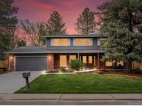 Charming two-story home featuring a well-manicured front yard at dusk at 5845 W Portland Dr, Littleton, CO 80128