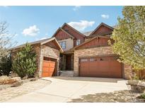 Beautiful home showcasing a three-car garage, stone accents, and a well-manicured lawn at 15711 Josephine Cir, Brighton, CO 80602