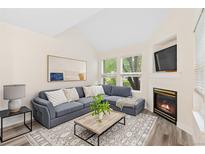 Vaulted living room with a comfortable sofa, indoor fireplace, and a great view of the outdoors at 2017 N Fork Dr, Lafayette, CO 80026