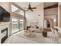 Bright living room featuring a fireplace, plush rug, and balcony access with sliding glass doors at 9481 E Mansfield Ave # 305, Aurora, CO 80014