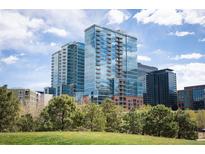 Modern glass-faced high rise condominium building with blue skies and green landscape at 1700 Bassett St # 609, Denver, CO 80202