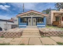 Charming blue duplex with a red tile roof and manicured front yard with stone landscaping at 2838 Decatur St, Denver, CO 80211