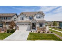 Charming two-story home with stone accents, a well-manicured lawn, and attached two car garage at 6307 Saddle Bow Ave, Parker, CO 80134