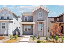 Charming gray two-story home featuring a covered porch and beautifully landscaped front yard at 8785 Whiteclover St, Littleton, CO 80125