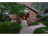 Charming brick home with a cozy front porch and well-maintained landscaping at 2232 S Ogden St, Denver, CO 80210