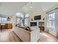 Bright living room features a fireplace, vaulted ceilings, and large windows providing ample natural light at 9573 Deerhorn Ct # 19, Parker, CO 80134