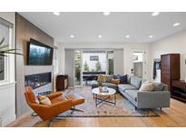 Bright living room featuring a fireplace, hardwood floors, modern furniture, and sliding glass door to outside patio at 2248 S Lincoln St, Denver, CO 80210