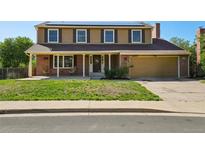 Charming two-story home with a brick and tan facade, solar panels, and a covered front porch at 3285 W 11Th Avenue Ct, Broomfield, CO 80020