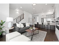 Bright living room with modern furnishings, open floor plan, and a view of the kitchen and staircase at 3040 Wilson Ct # 2, Denver, CO 80205