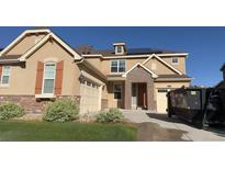 Two story home with brick accents, tan stucco, complemented by a well-maintained front yard at 10207 Isle St, Parker, CO 80134