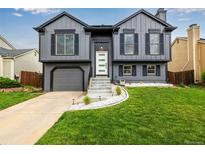 Charming two-story home with gray siding, black shutters, and a well-manicured lawn and appealing curb appeal at 19661 E Girard Ave, Aurora, CO 80013