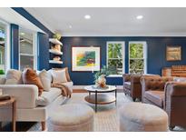 Inviting living room with dark blue walls, hardwood floors, and plenty of natural light at 5643 S Fulton Way, Greenwood Village, CO 80111