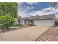 Charming single-story home with blue siding, brick accents, a well-maintained lawn, and an attached two-car garage at 17731 E Bails Pl, Aurora, CO 80017