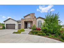 Charming home with a stone-accented entrance and well-maintained landscaping at 5608 Raintree Dr, Parker, CO 80134