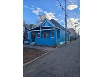 Charming blue home featuring a covered front porch and classic architectural details at 924 W 9Th Ave, Denver, CO 80204