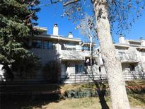 Exterior view of a townhome complex with balconies and a well-maintained lawn on a sunny day at 1825 Kendall St # 205, Lakewood, CO 80214