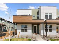Modern home featuring multi-tone exterior, with a covered porch and decorative stone landscaping at 2466 S Cherokee St, Denver, CO 80223