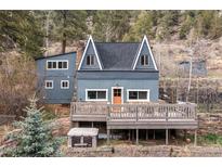 Charming mountain home featuring a spacious deck, unique architecture, and nestled amongst beautiful trees at 1264 Beaver Brook Canyon Rd, Evergreen, CO 80439