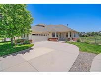 Charming single-story home with manicured lawn, mature tree, and a curved driveway at 7912 S Buchanan Way, Aurora, CO 80016