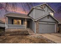 Two-story house with gray siding, brick accents, and a landscaped yard at 11455 River Run Pkwy, Commerce City, CO 80640