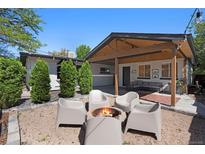 A cozy backyard setting with a fire pit and comfortable seating area under a covered patio at 9400 Ridge Rd, Arvada, CO 80002