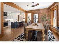 Inviting dining room featuring exposed brick, wood beams, and open layout to kitchen at 1050 N Clarkson St, Denver, CO 80218