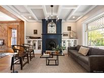 Bright living room boasts fireplace, coffered ceilings, and abundant natural light at 1050 N Clarkson St, Denver, CO 80218