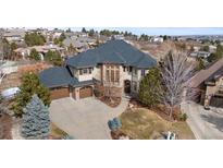 Stunning two-story home featuring a three-car garage, mature trees, and beautifully landscaped grounds at 1039 Buffalo Ridge Way, Castle Pines, CO 80108