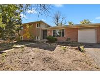 Ranch style home with brick exterior, attached garage, and landscaping at 14066 E 27Th Ave, Aurora, CO 80011