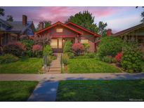 Charming brick home with beautiful landscaping, green lawn, and inviting curb appeal at 2541 Bellaire St, Denver, CO 80207