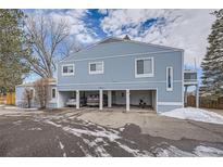 Two-story blue condo features covered parking, a deck, and well-maintained landscaping at 7904 Chase Cir # 147, Arvada, CO 80003