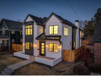 Stunning two-story home featuring elegant white brick, striking black trim, and warm, inviting exterior lighting at 352 S High St, Denver, CO 80209