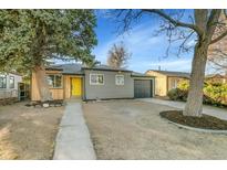 Charming home with a tidy front yard, gray siding, a yellow door, and an attached garage at 1765 Kingston St, Aurora, CO 80010