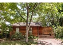Charming home featuring wood siding, mature trees, a brick walkway, and an inviting front porch at 1878 S Gilpin St, Denver, CO 80210