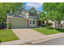 Charming two-story home with a well-maintained lawn and mature trees offering shade and curb appeal at 20922 E Crestline Cir, Centennial, CO 80015